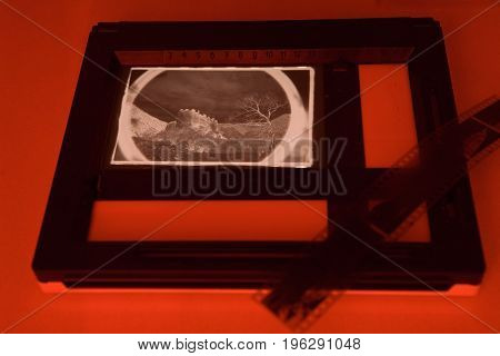Analog photo projection of photos in the light of a red light. Inversion of the landscape with the ancient Georgian fortress of Petresciche.