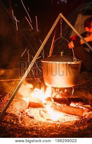 boiling pot over an open fire on a blurred background.