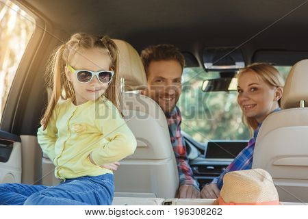 Travel by car family ride together daughter playing with sunglasses