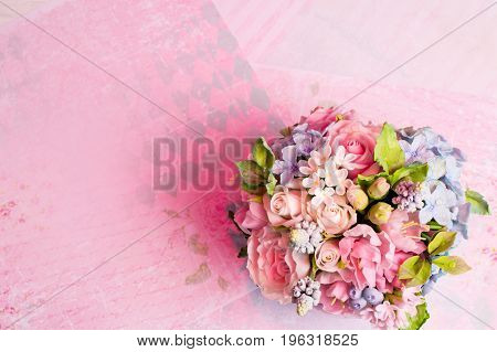 a bouquet of flowers on a pink background in style shabby chic.