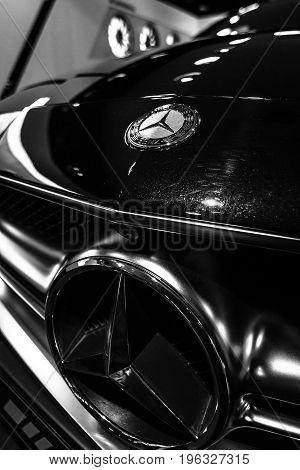 BERLIN - JANUARY 24 2015: Showroom. Hood ornament and emblem of a mid-size luxury car Mercedes-Benz CLS 63 AMG. Black and white. Produced since 2013.