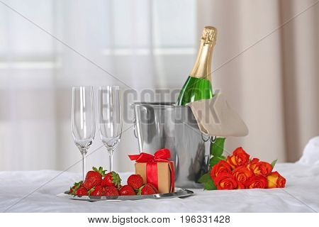 Romantic composition with champagne and strawberry on bed. Honeymoon concept