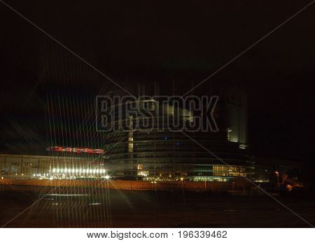 STRASBOURG FRANCE - NOV 30 2017: European Parliament in Strasbourg at night with traces from star filter and all European Union Flags waving