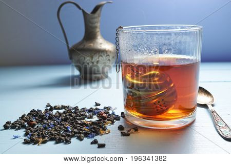 Closeup Glass Of Hot Tea With Tea Strainer And Tea Leaves
