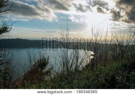 View of the slopes, forests and hills of Lake Albano in a cloudy sunset. Albano is a quiet and bucolic countryside region near Rome. Located in the Lazio region, central Italy