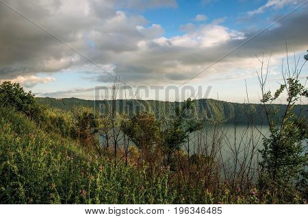 View of the slopes, forests and hills of Lake Albano in a cloudy sunset. Albano is a quiet and bucolic countryside region near Rome. Located in the Lazio region, central Italy