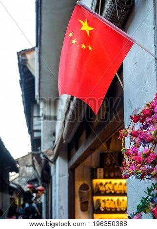 Suzhou, China - Nov 5, 2016: A flag of China located outside a store, along shopping street, at the historic Zhouzhuang Water Town.
