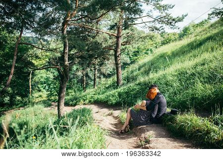 couple resting on park trail and hugging each other