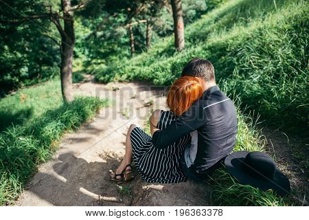 couple resting on park trail and hugging each other