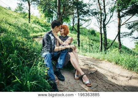 portrait of beautiful young pair in a park sitting on the ground