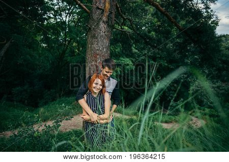 Love couple kissing under a tree, readhead girlfriend