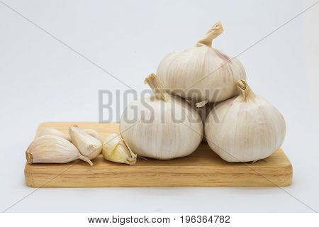 Fresh rood garlic on wooden board on white background