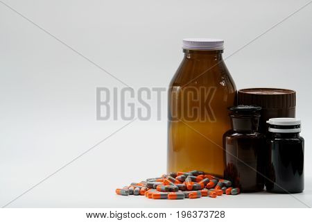 Capsule pills with amber bottles on white background
