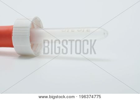 Orange medical plastic dropper with on white background