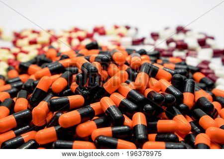 Orange black white red pale yellow capsule pills