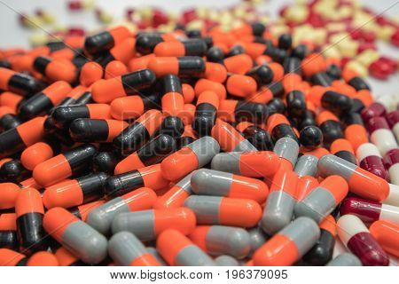 Orange black grey white red pale yellow capsule pills