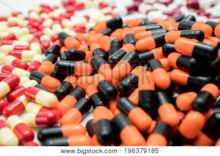 Orange black white red pale yellow capsule pills