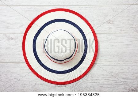 Pretty straw hat with ribbon and bow on white background. Beach hat closeup top view isolated