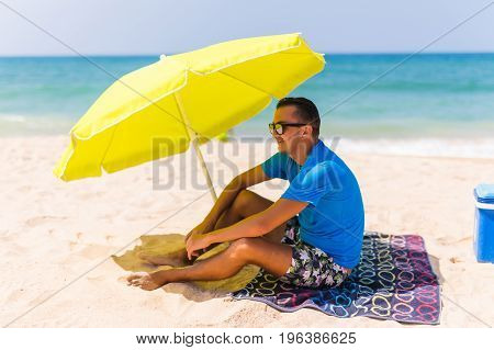 Lazing Man In Sun  Under Solar Umbrella On Towel Enjoy The Lazy Time On The Beach