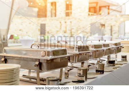 Buffet heated trays standing in line ready for service. Outdoors buffet restaurant, the hotel restaurant
