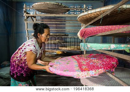 villagers of Ban Sanuan Nok Buriram Province. Thailand - April 30 2017: old women activists are presenting silkworms in farm.traditional thai fabric at Burirum Thailand. The local silk cloth is characterised by elaborate patterns and design