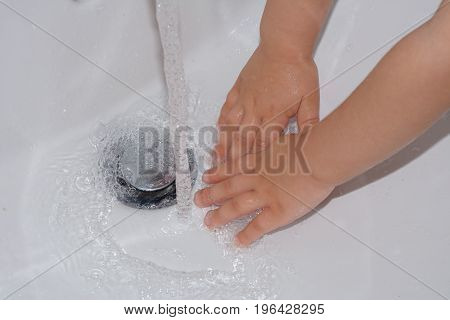 Child washing hand with water for hygiene
