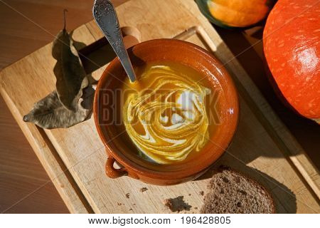 Pumpkin and carrot soup with cream and parsley