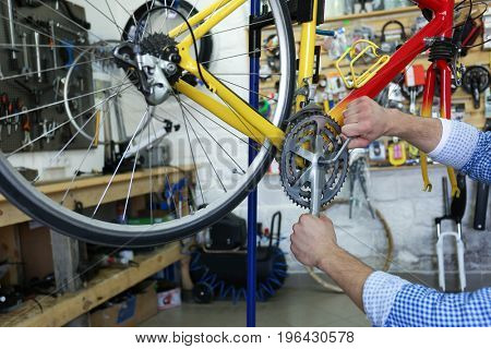 Young man working in bicycle repair shop, closeup