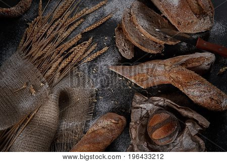Mixed breads and rolls shot from above on a black background.