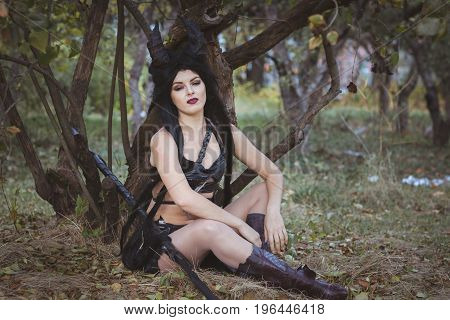Beautiful woman from the tribe sits under a tree