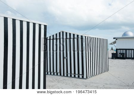 Striking black and white verticlly striped beack shed on beach Miami Florida