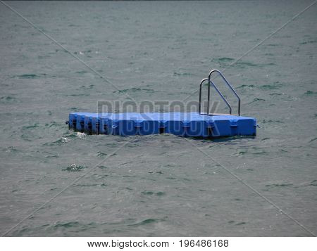 Isolated Blue Ponton Swimming Platform on Stormy Cold Water