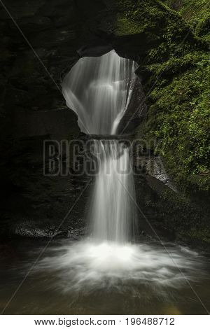Beautiful Flowing Waterfall With Magical Fairytale Feel In Lush Green Forest Location