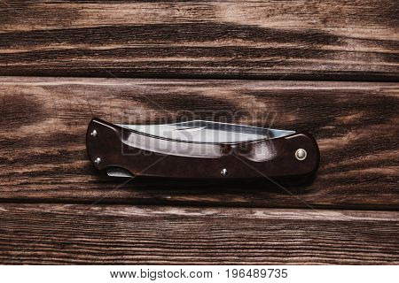 Jackknife on a wooden background top view.