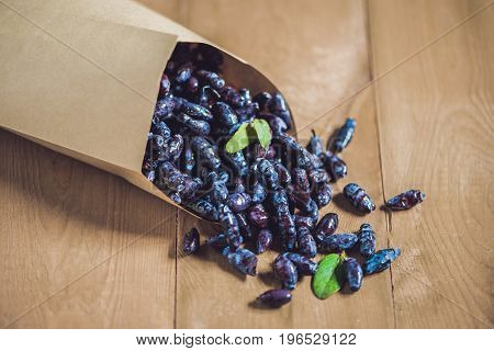 Fresh Honeysuckle Blue Berry Fruits With Leaf On A Wooden Background