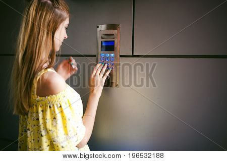 Woman Dials An Apartment Code On An Electronic Doorphone Panel