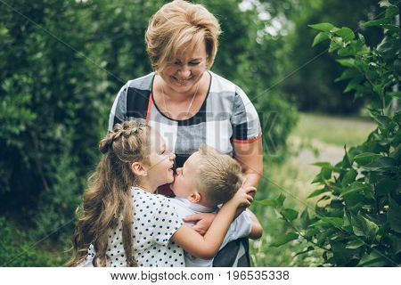 Grandmother playing in the park with grandchildren, siter with brother