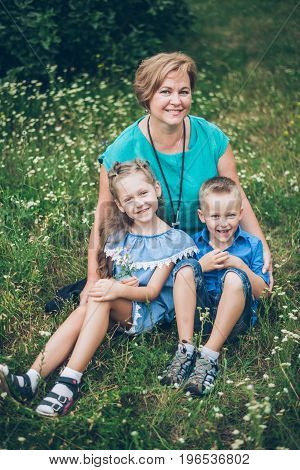 Grandmother playing in the park with grandchildren, siter with brother