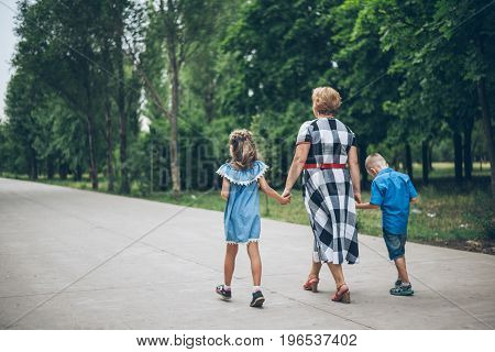 Grandmother playing in the park with grandchildren, siter with brother
