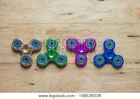 Colored Fidget Spinners Stress Relieving Toy On Wooden Background