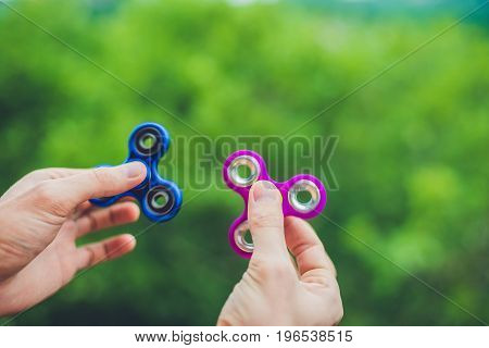 Close Up Of A Man's Hand Who Is Holding A Fidget Spinner In A Park