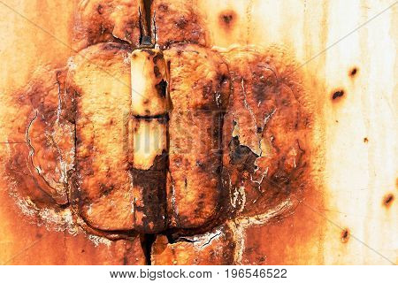 An abstract image of a very old and rusted metal door hinge.