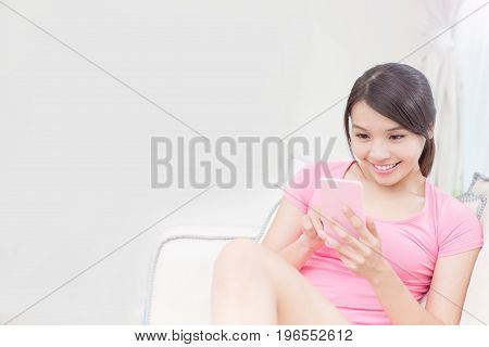 woman use phone and sit on sofa with tv in the room