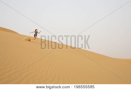 Woman Running In Rub Al Khali Desert At The Empty Quarter, In Abu Dhabi, Uae