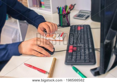Businessman calculating the financial statements. Close up young man with calculator counting making notes at home. man working on computer in a office - color / Old Polaroid