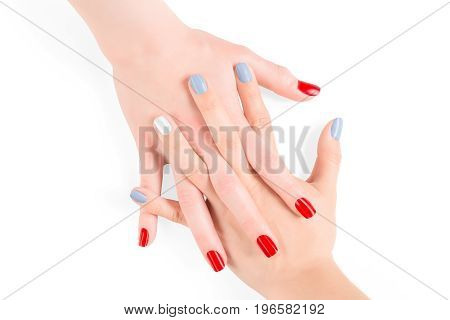 Woman connected hands with red and blue shellac nail polish. Isolated on white clipping path included