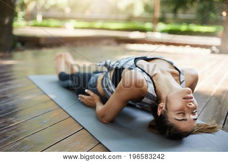 Young girl practicing matsyasana on a sunny summer day.