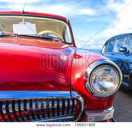 Russia Kamchatka - 05 October 2017: Red vintage car GAZ-21 on a festival of old cars on Kamchatka. Retro car's headlight close up.