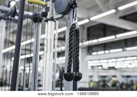 Closeup picture of hanging handle machine in a gym for pulling training.