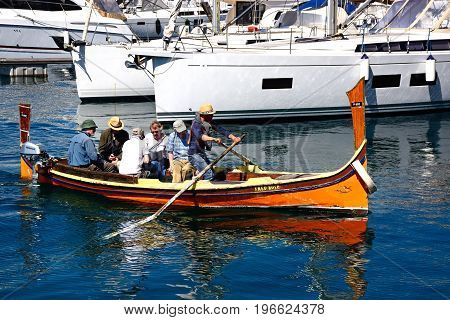 VITTORIOSA, MALTA - MARCH 31, 2017 - Passengers on board a traditional Maltese Dghajsa water taxi in the harbour Vittoriosa Malta Europe, March 31, 2017.